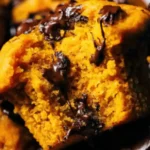 Golden pumpkin chocolate chip muffins fresh from the oven with melty chocolate chips on top