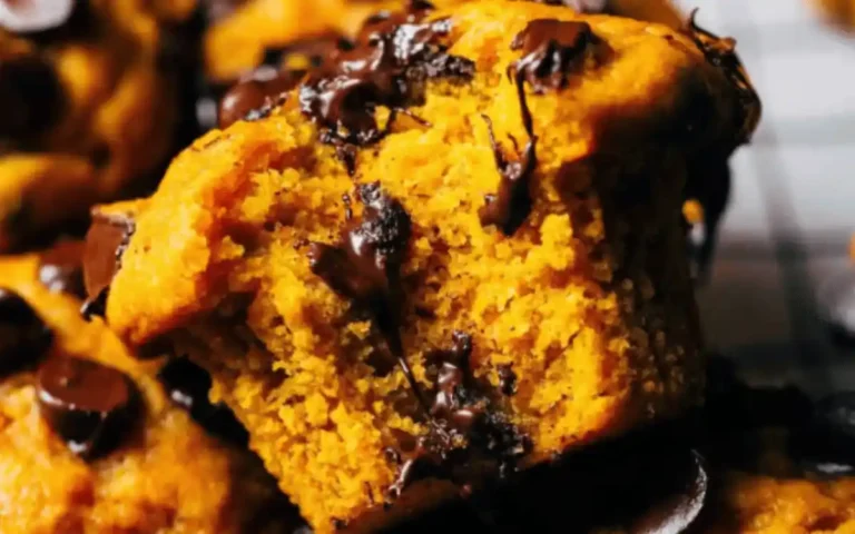 Golden pumpkin chocolate chip muffins fresh from the oven with melty chocolate chips on top