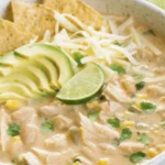 Bowl of creamy white chicken chili topped with cilantro and shredded cheese
