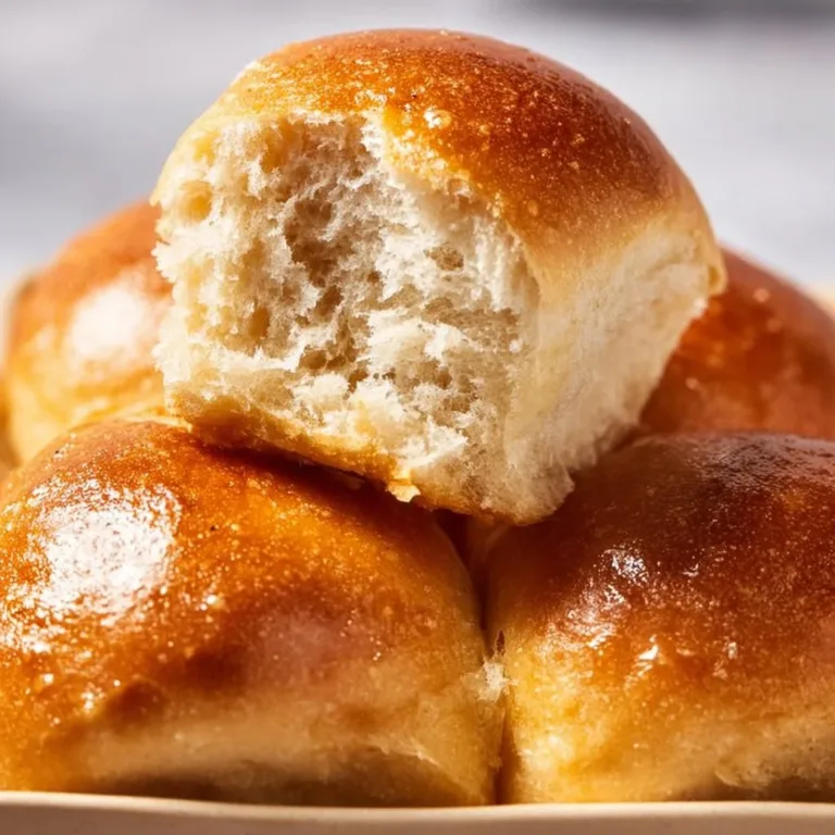 Freshly baked whole wheat dinner rolls on a wooden table