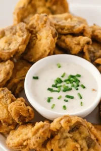 Deliciously crispy fried mushrooms served on a plate with herbs.