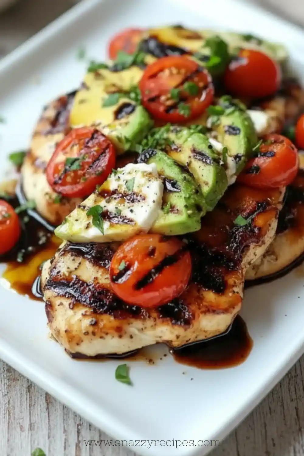 Juicy grilled avocado chicken served on a plate with fresh herbs and vegetables.