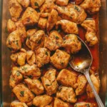 Oven-baked chicken bites served on a plate with dipping sauce