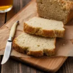 Loaf of Classic Beer Bread with beer bottle on a wooden table