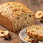Freshly baked easy apple bread loaf on a wooden table.