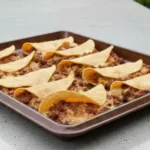 Crispy ground beef tacos filled with fresh toppings and served on a plate.