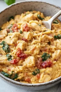 Slow Cooker Creamy Tuscan Chicken Orzo served in a bowl with garnishes