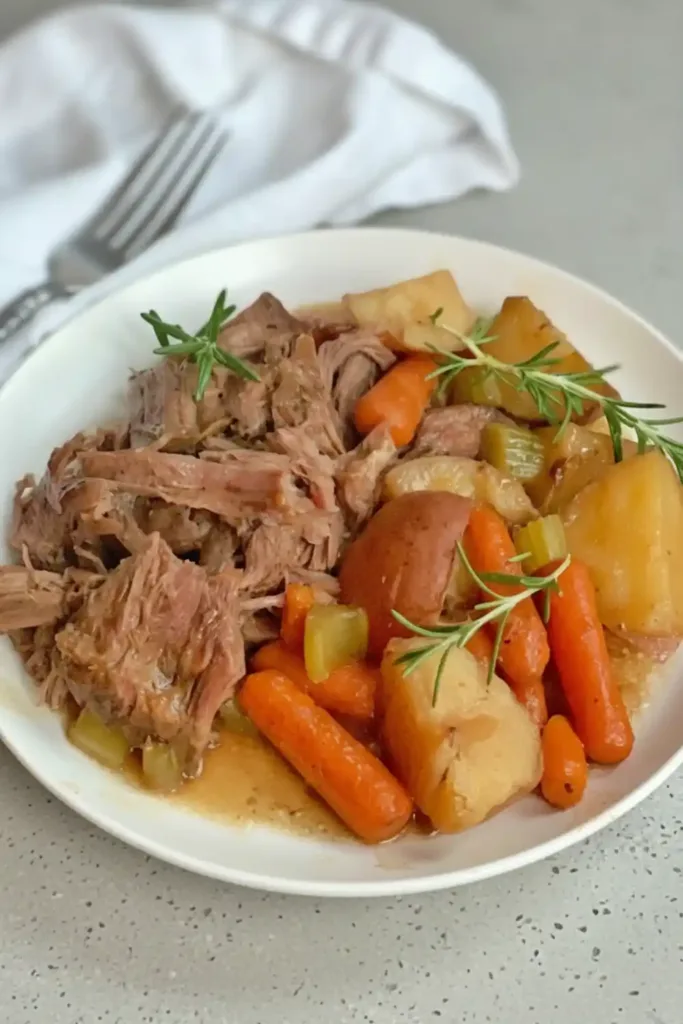 Easy slow cooker pot roast with vegetables in a ceramic dish