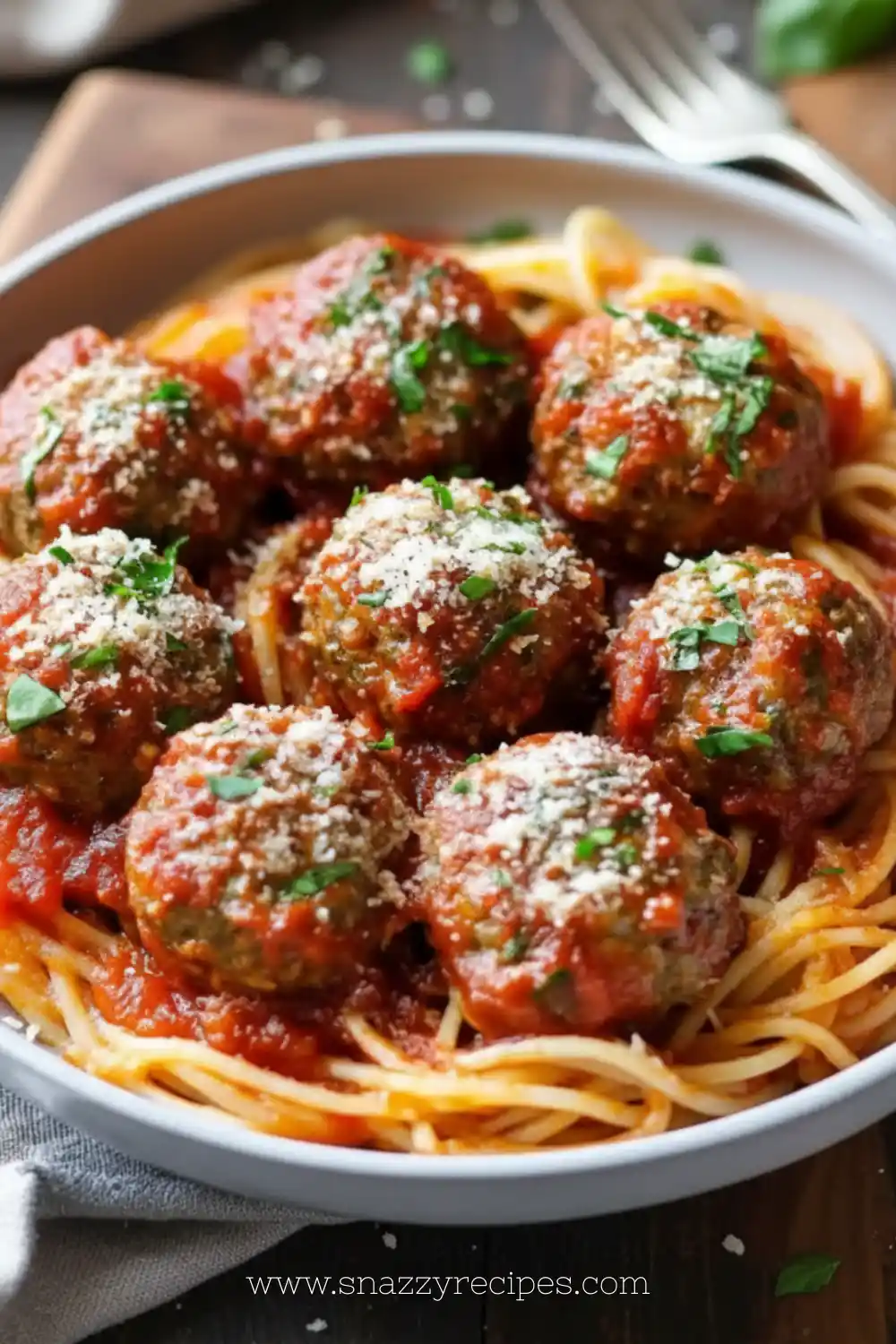 Plate of classic Italian meatballs garnished with parsley and served with tomato sauce.