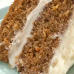 Slice of easy homemade carrot cake with cream cheese frosting on a plate